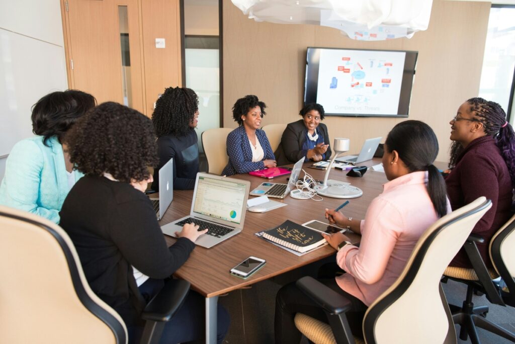 Group of people meeting around a table with laptops and notes